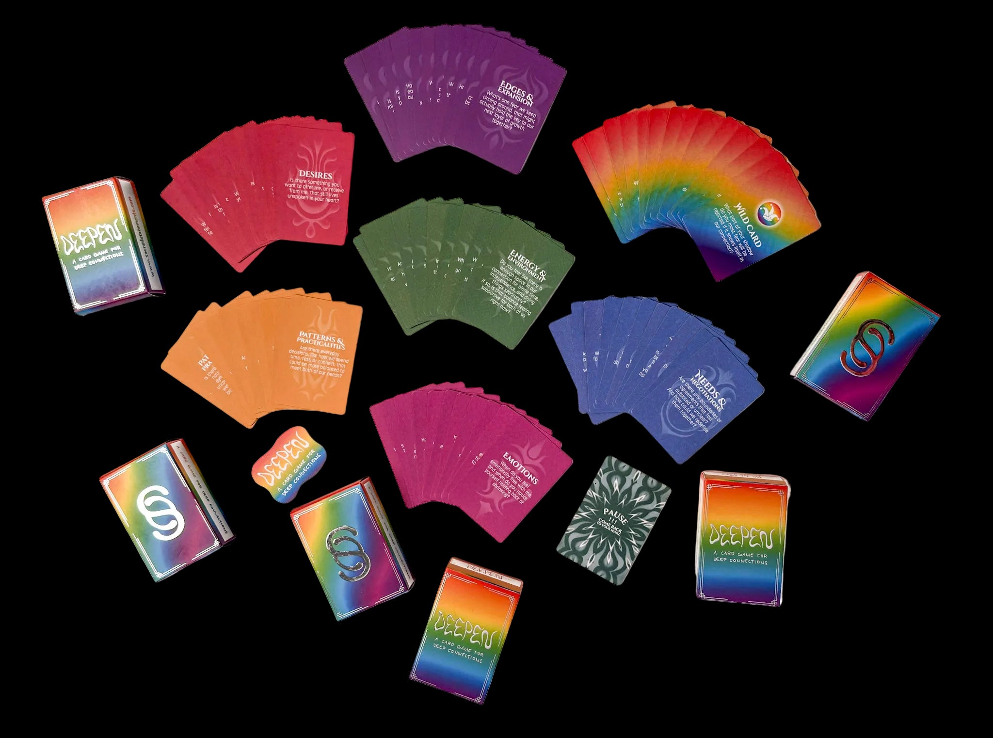 A set of colorful deck boxes and fanned oracle cards arranged on a plain white background. The boxes feature a rainbow gradient design, and the cards are shown in multiple colors including purple, red, green, orange, blue, and pink.